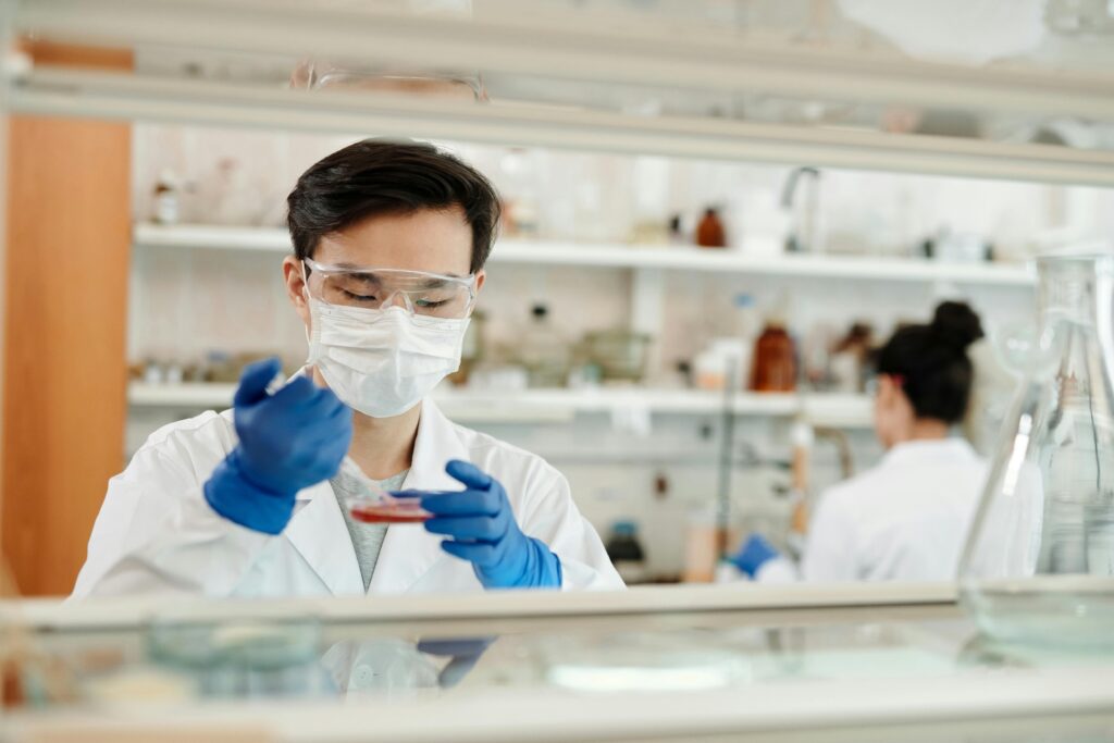 A scientist using a pipette in a petri dish.