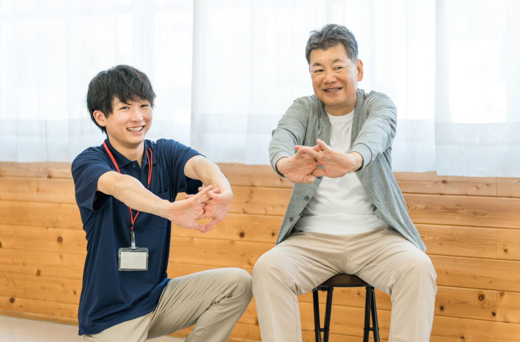 This caregiver and patient are stretching together to maintain their health.